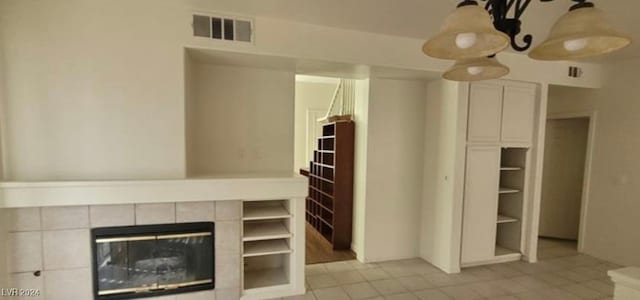 unfurnished living room featuring a tiled fireplace and light tile patterned floors