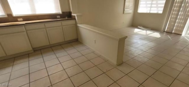 kitchen with light tile patterned floors and cream cabinets