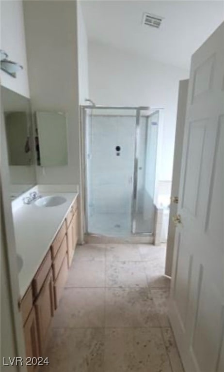 bathroom featuring tile patterned flooring, vanity, and walk in shower