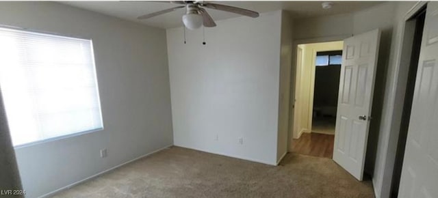 unfurnished bedroom featuring ceiling fan and light carpet