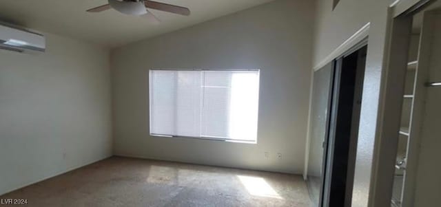 spare room with carpet floors, ceiling fan, a wall mounted AC, and vaulted ceiling