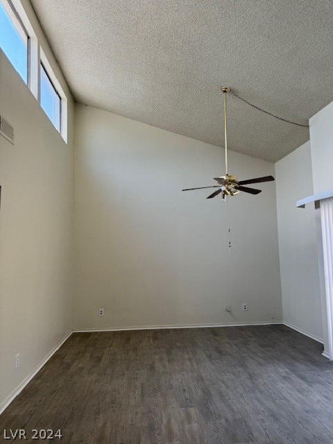 spare room featuring lofted ceiling, a textured ceiling, dark hardwood / wood-style flooring, and ceiling fan