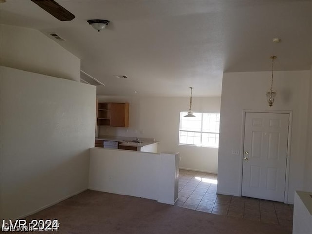 kitchen with pendant lighting, kitchen peninsula, sink, ceiling fan, and dark carpet