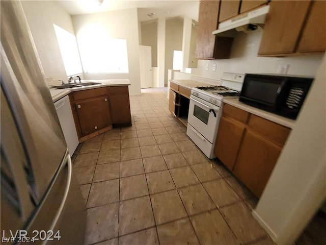 kitchen with sink, white appliances, and light tile patterned floors