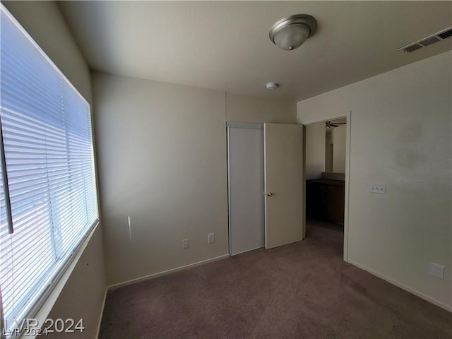 unfurnished bedroom featuring dark colored carpet