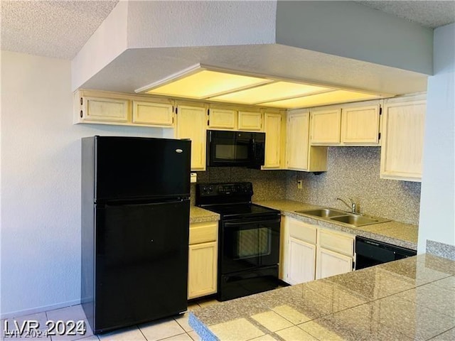 kitchen featuring a textured ceiling, black appliances, tasteful backsplash, sink, and light tile patterned flooring