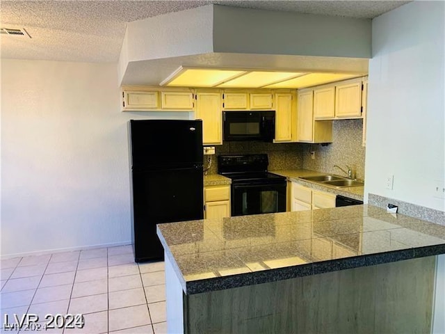 kitchen with light tile patterned floors, kitchen peninsula, tasteful backsplash, black appliances, and sink