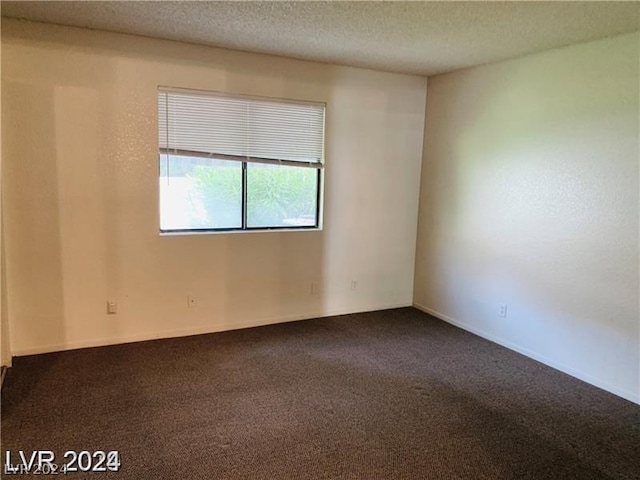 carpeted empty room with a textured ceiling