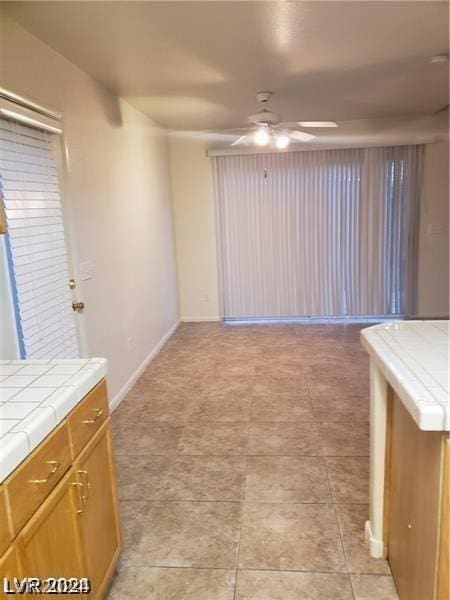 interior space featuring tile counters and ceiling fan