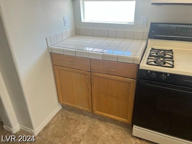 kitchen featuring tile counters and range with gas stovetop