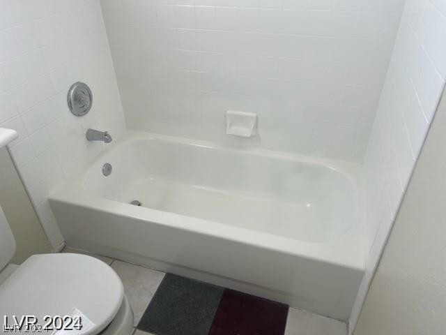 bathroom featuring tile patterned floors, toilet, and  shower combination