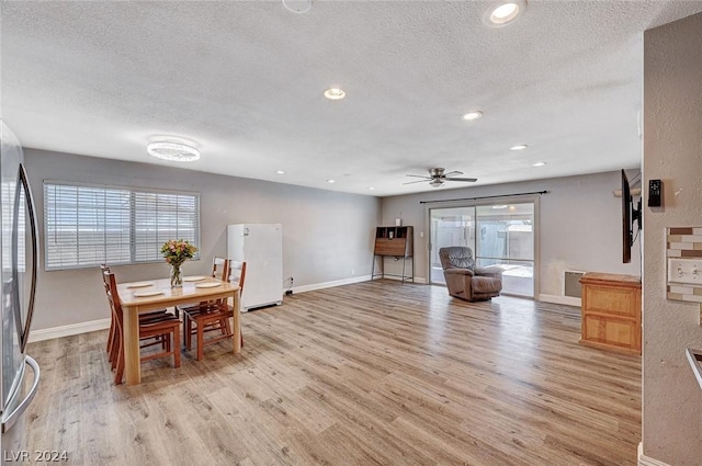 dining area featuring ceiling fan, light hardwood / wood-style floors, and a textured ceiling