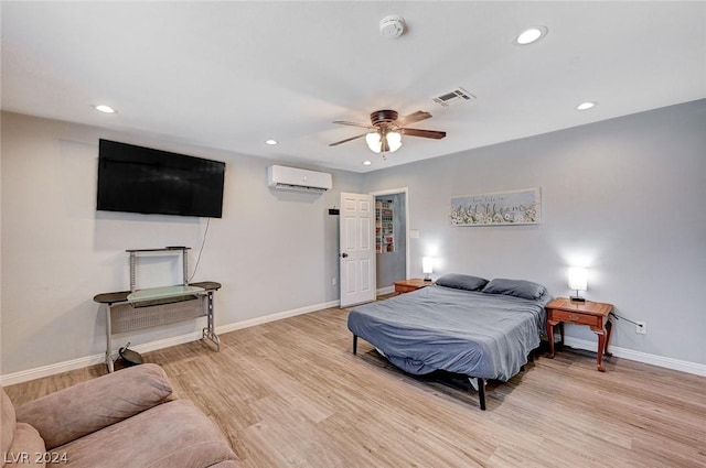 bedroom featuring an AC wall unit, ceiling fan, and light hardwood / wood-style flooring