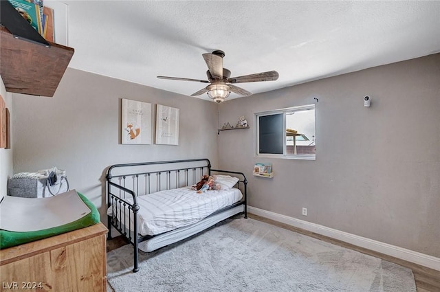 bedroom featuring ceiling fan, a textured ceiling, and hardwood / wood-style flooring