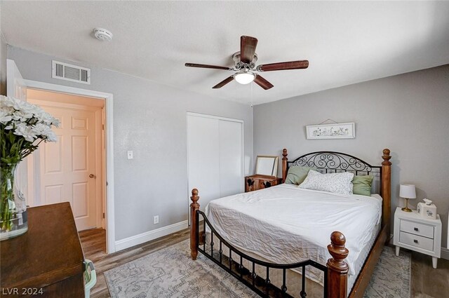 bedroom with hardwood / wood-style flooring, ceiling fan, and a closet