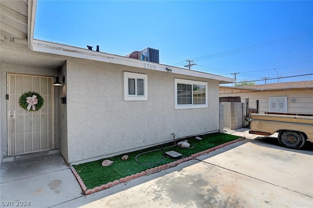 view of side of property with a patio and central AC unit