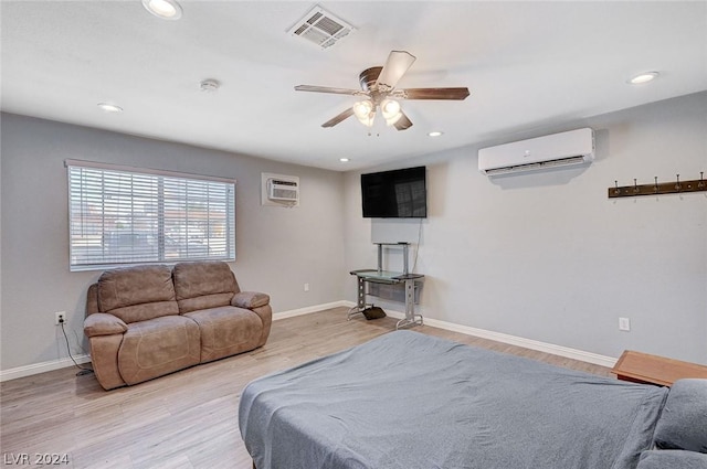 bedroom featuring a wall mounted AC, ceiling fan, and light hardwood / wood-style floors