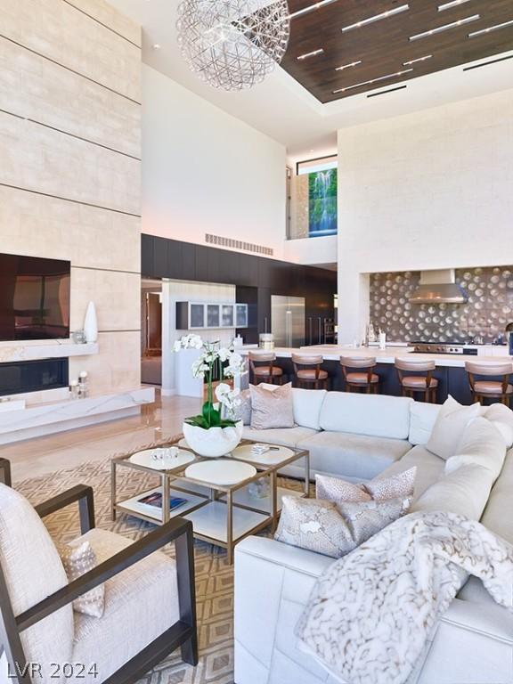 living room with a towering ceiling, wooden ceiling, and a chandelier