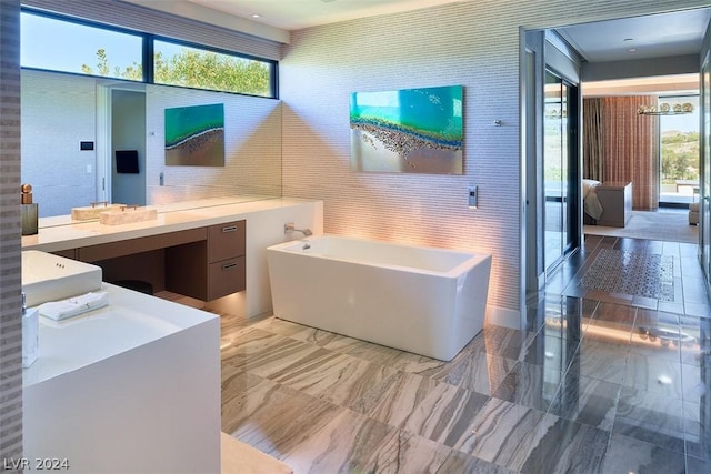 bathroom featuring tile walls, a washtub, and vanity