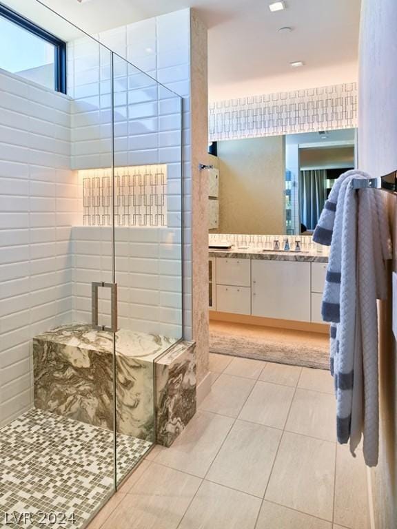 bathroom with walk in shower, tile patterned flooring, and vanity