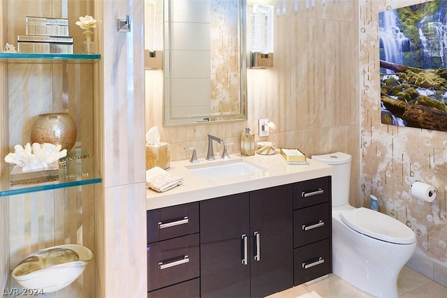 bathroom featuring toilet, vanity, tile patterned floors, and tile walls