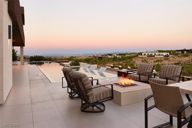 patio terrace at dusk featuring a fire pit