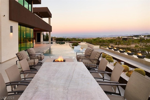 patio terrace at dusk featuring an outdoor fire pit