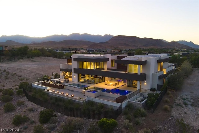 rear view of house with a patio, a balcony, and a mountain view