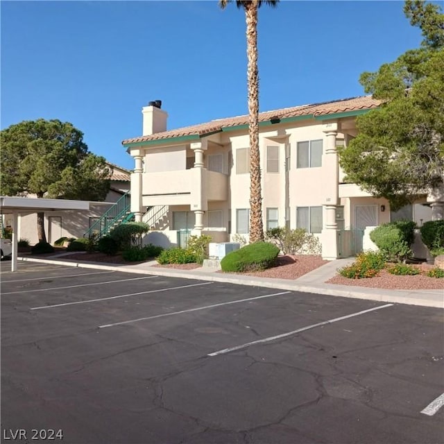 1409 Cedar Rock Ln Unit 101, Las Vegas, NV 89128 - view of building exterior featuring uncovered parking and stairway