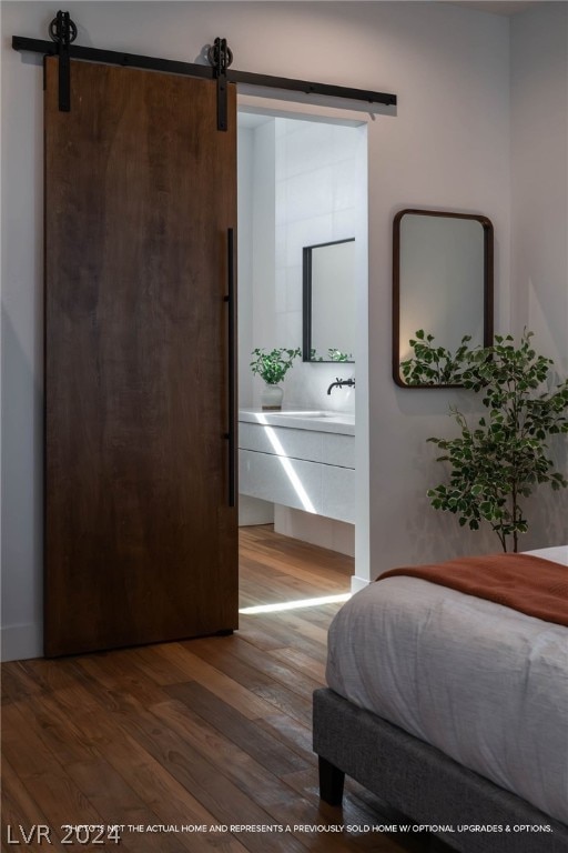 bedroom with hardwood / wood-style flooring and a barn door