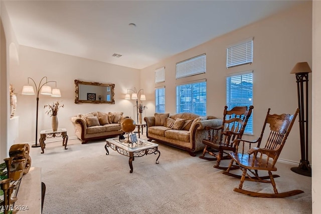 carpeted living area with baseboards and visible vents