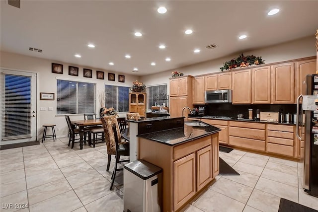 kitchen featuring light tile patterned floors, visible vents, appliances with stainless steel finishes, light brown cabinetry, and a sink