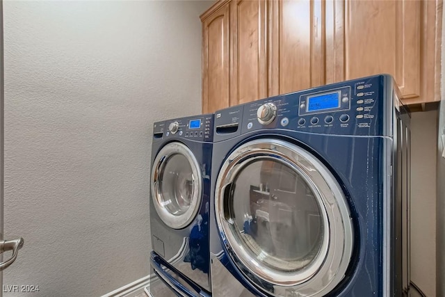 washroom with a textured wall, separate washer and dryer, and cabinet space