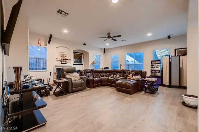 living room with visible vents, arched walkways, light wood-style flooring, and recessed lighting