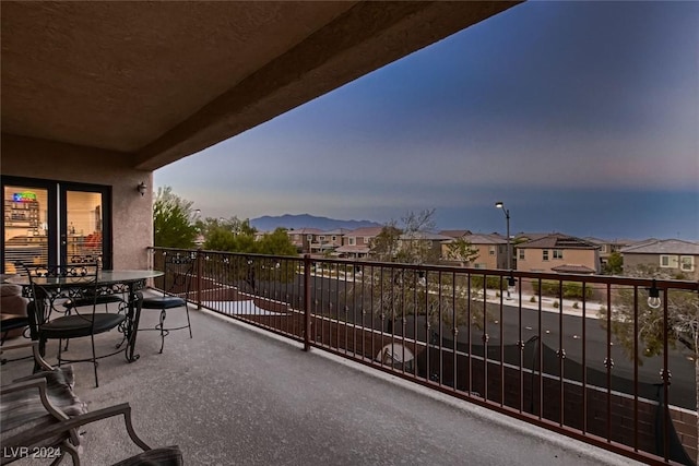 balcony at dusk featuring a residential view