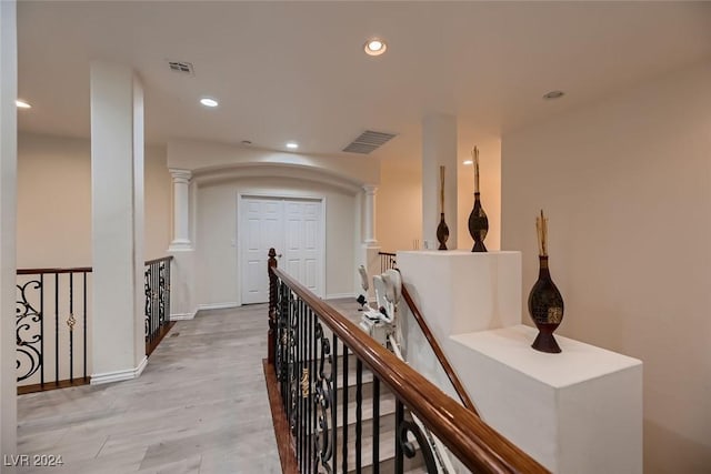 hallway with recessed lighting, visible vents, and an upstairs landing