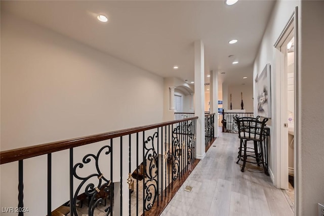 hall with decorative columns, wood finished floors, and recessed lighting