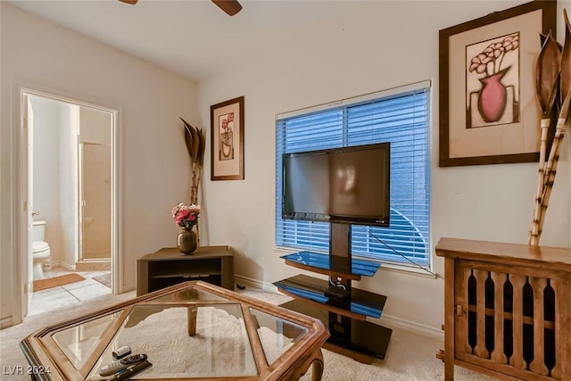 carpeted living area with a ceiling fan and baseboards