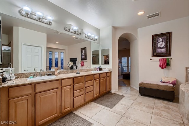 full bathroom featuring double vanity, tile patterned flooring, visible vents, and a sink