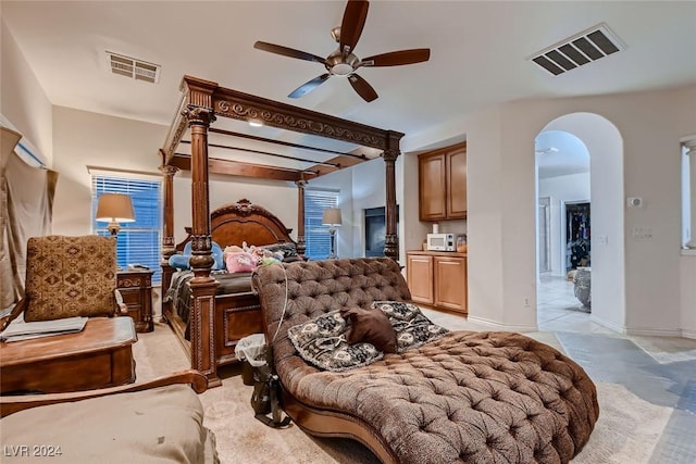 bedroom featuring arched walkways, baseboards, visible vents, and a ceiling fan