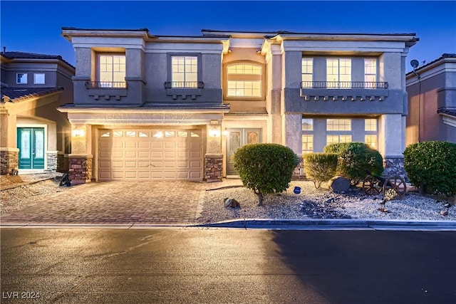 view of front of home with decorative driveway, french doors, stucco siding, a garage, and stone siding