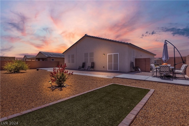 back of house with a patio area, a tile roof, fence, and stucco siding