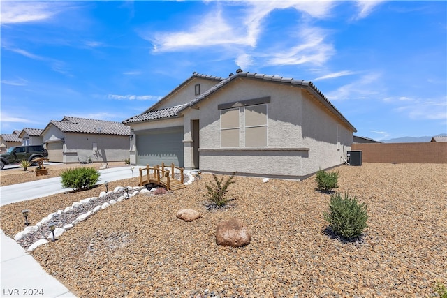 view of front of property with driveway, a tile roof, a garage, and stucco siding