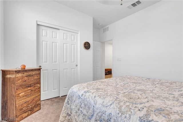 bedroom with light carpet, a closet, visible vents, and a ceiling fan