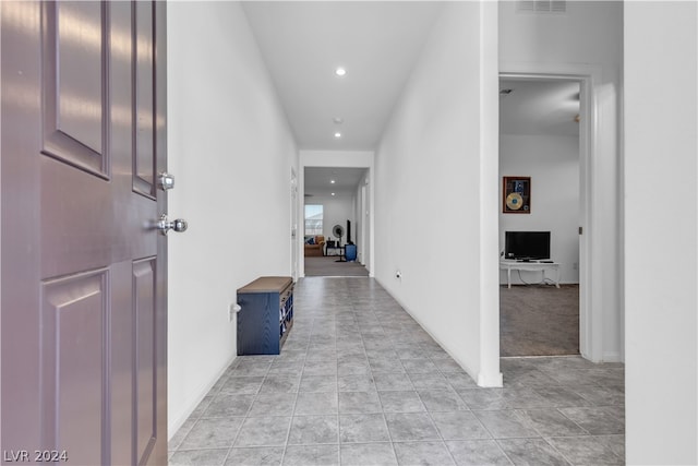 hallway featuring baseboards, light tile patterned flooring, visible vents, and recessed lighting