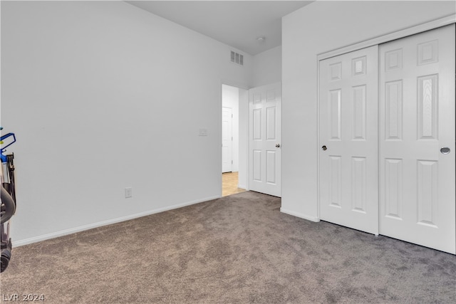 unfurnished bedroom featuring carpet floors, a closet, visible vents, and baseboards