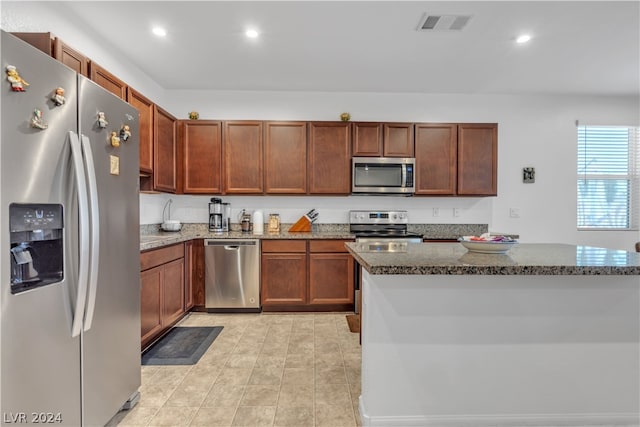 kitchen with light tile patterned floors, recessed lighting, visible vents, appliances with stainless steel finishes, and dark stone counters