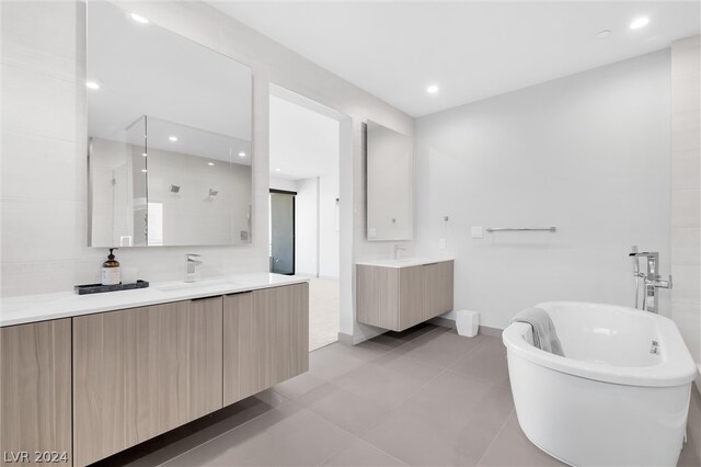 bathroom featuring tile patterned flooring, independent shower and bath, and vanity