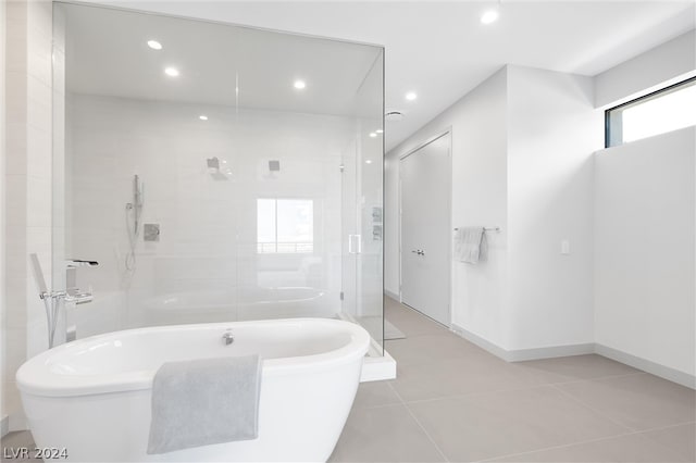 bathroom with tile patterned flooring and shower with separate bathtub