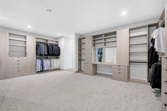 walk in closet featuring light colored carpet